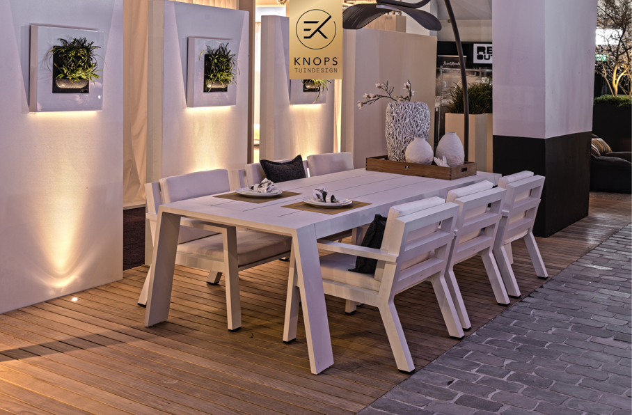 sfeertuinen zwembad meerstammige bomen tuin verlichting avond witte polyester bakken knops tuindesign tuinarchitect overkapping wellness luxe buitenhaard vlonder